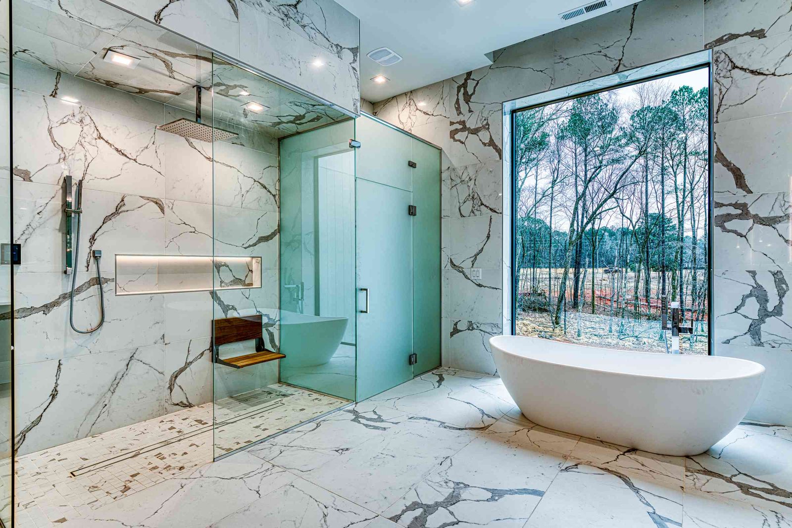Lower level primary bathroom with dark stone by Shail Construction in Raleigh NC