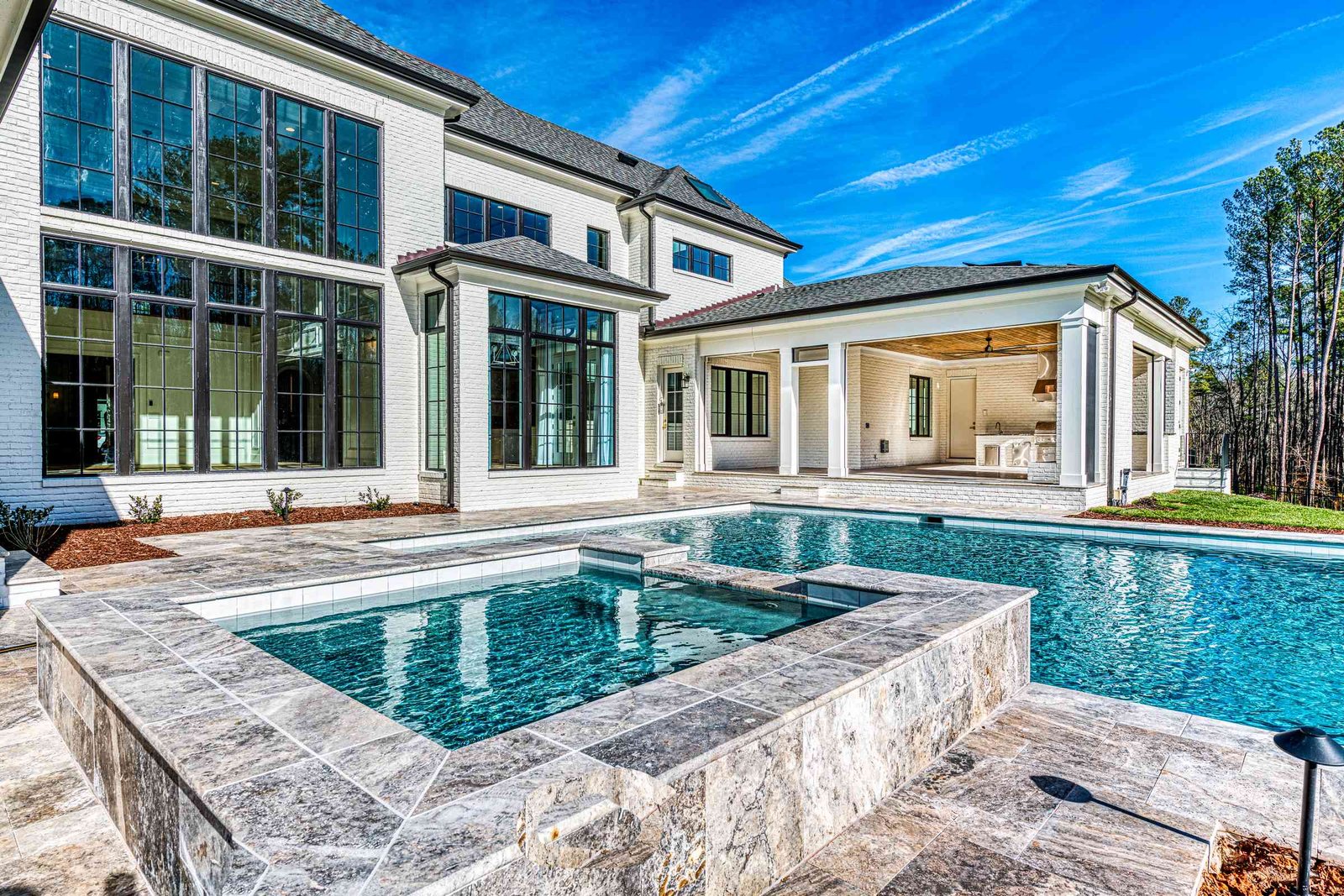 Pool with raised spa and waterfall feature by Shail Construction in Raleigh NC