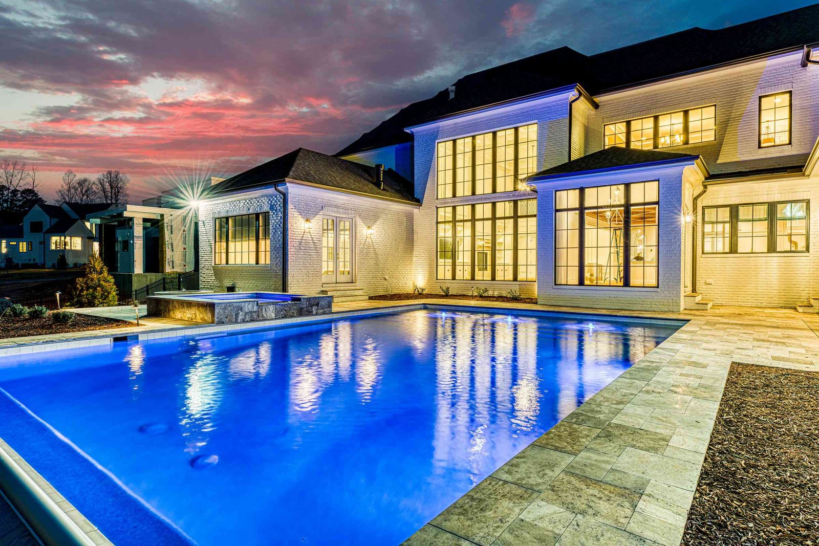 Twilight pool view with house in background by Shail Construction in Raleigh NC